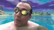 a shirtless man wearing sunglasses is swimming in a pool of water .