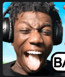 a man wearing headphones is making a funny face with his tongue out