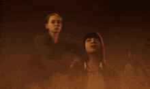 a man and a woman are standing in a dark room with a ghost behind them