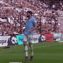 a man in a blue shirt is running on a soccer field in front of a sign that says 24 league