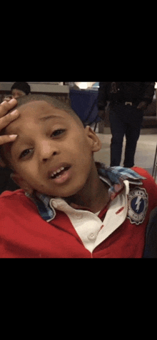 a young boy wearing a red shirt with the letter f on the front