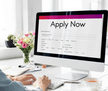 a person is using a computer to fill out a form that says apply now