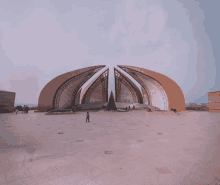 a man stands in front of a large building that looks like a pyramid