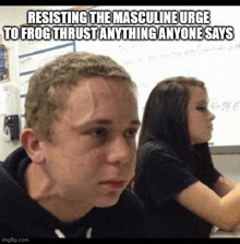 a man and a woman are sitting in a classroom with a meme that says resisting the masculine urge to frog thrust