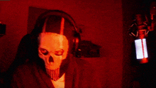 a person wearing a skull mask and headphones is standing in front of a microphone