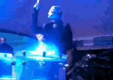 a man in a mask plays drums in a dark room