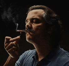 a man with a mustache is smoking a cigar with a match in his mouth