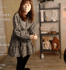 a woman in a leopard print dress is standing in front of a bookshelf with a book titled loewe on it