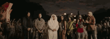 a group of people dressed in costumes are standing next to each other at night .