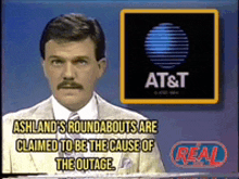 a man with a mustache is standing in front of an at & t logo