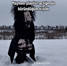 a woman smoking a cigarette in the snow with a caption that says mayhem playlist