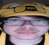 a close up of a man wearing glasses and a yellow hat