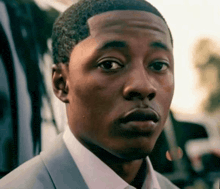a man in a suit and white shirt is making a surprised face .