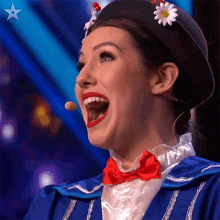 a woman in a blue and white costume with a red bow tie and a black hat with daisies on it