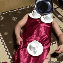 a person in a red dress is laying on the floor with cups and saucers around their head .