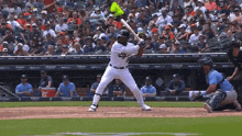 a baseball player getting ready to swing at a pitch with a sign that says ' tigers ' on it