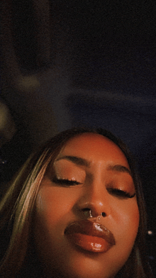 a woman with a nose ring looks at the camera