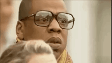 a man wearing glasses and a scarf is looking at something .