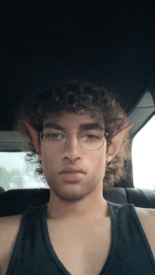 a man wearing glasses and elf ears is sitting in the back seat of a car