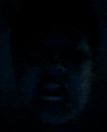 a close up of a man 's face in the dark .