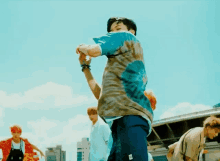 a group of young men are dancing on a rooftop in a city .