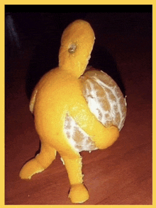 a peeled orange is shaped like a duck on a table