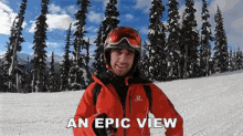 a man in a red jacket and helmet stands on a snowy slope with the words an epic view below him