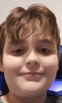 a close up of a young boy 's face with brown hair