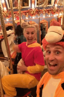 a man and a woman are posing for a picture in front of a merry go round and the caption says @joshsm