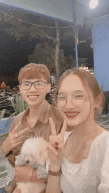 a man and a woman are posing for a picture with a small white dog