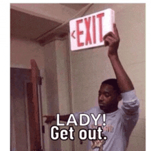 a man is holding up an exit sign that says lady get out .