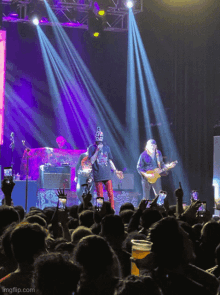 a man playing a guitar in front of a crowd with the url imgflip.com