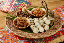 a wicker tray with a variety of food including rice cakes