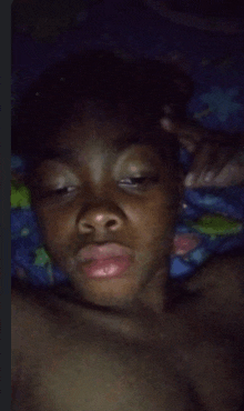 a young boy laying in bed with his eyes closed and his hand on his forehead