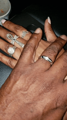 a man and woman 's hands with rings on them