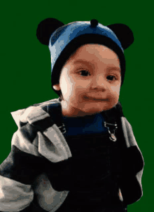 a young boy wearing a mickey mouse hat and a jacket