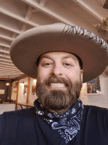 a man with a beard wearing a hat and a bandana