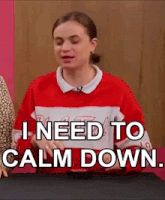 a woman in a red and white sweater is sitting at a table .
