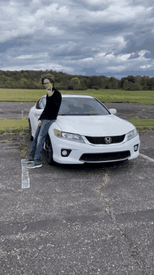 a man standing next to a white honda accord in a parking lot