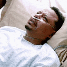 a man is laying in a hospital bed with an oxygen mask on his nose