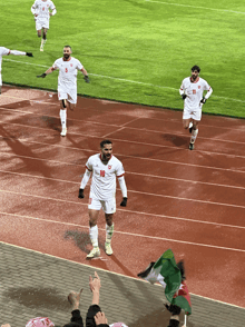 a soccer player with the number 10 on his jersey is running on a track
