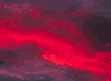 red clouds in a dark sky at sunset .