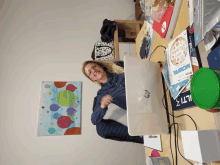 a woman sits at a desk with a laptop and a book that says microfoil