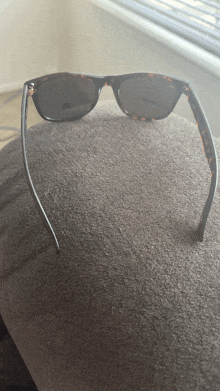 a pair of sunglasses is sitting on a brown cushion