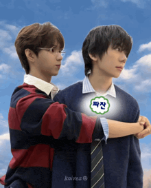 two boys are hugging each other with a sticker on their chest that says knives