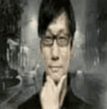 a man wearing glasses is holding his hand to his chin and looking at the camera .