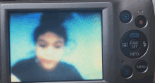 a camera displays a blurry picture of a girl with the auto function set button visible