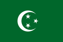 a green flag with three white stars and a crescent moon