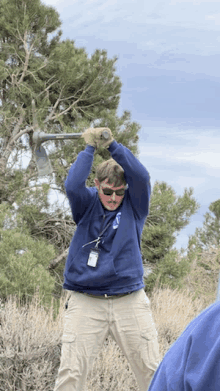 a man in a blue sweatshirt has a name tag on his neck that says ' scott '