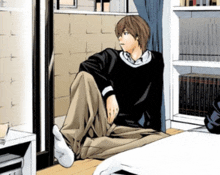 a man sits on the floor in a room with bookshelves